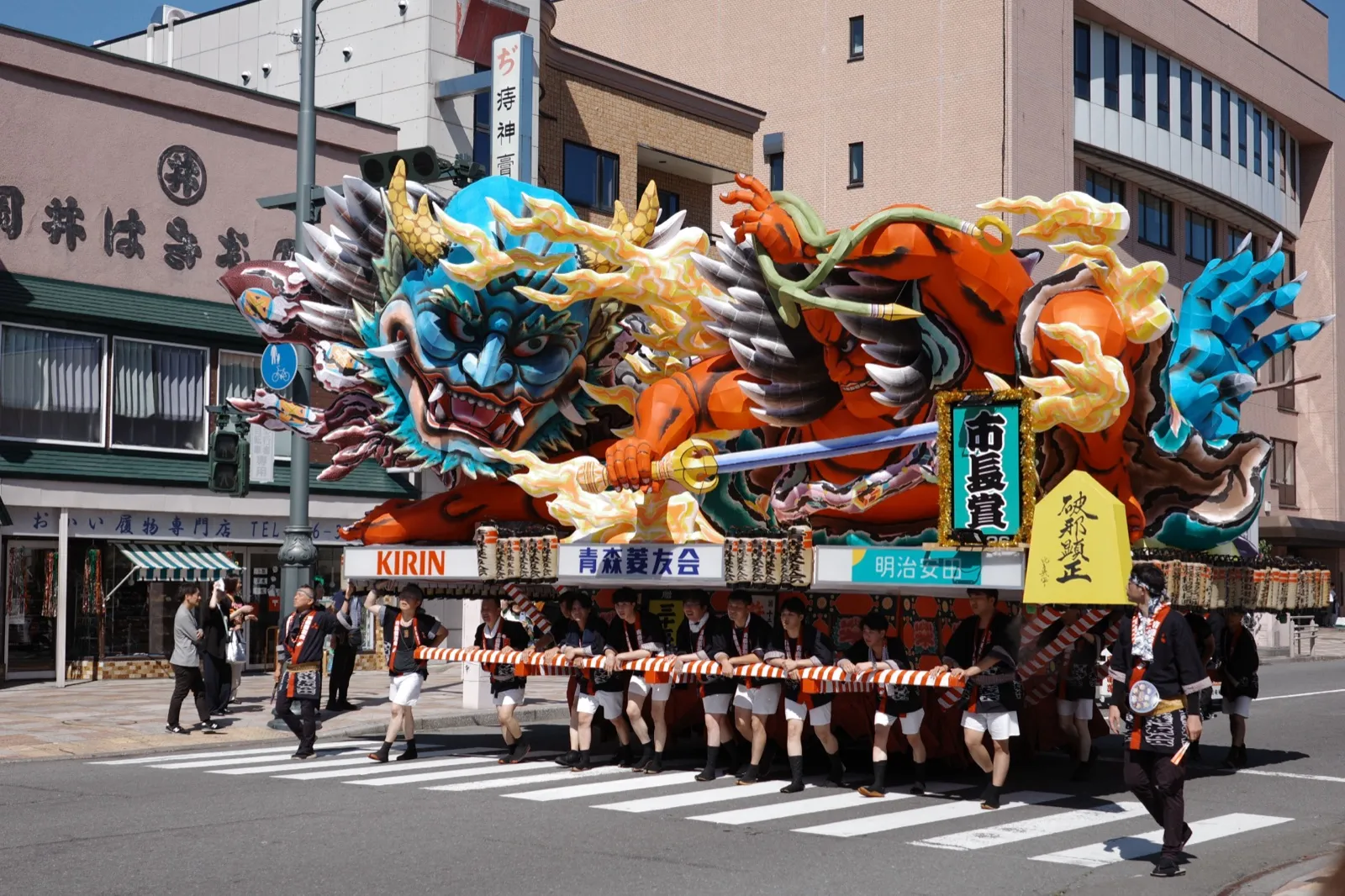 青森市内の交差点を曲がる青森ねぶた祭の大型ねぶた「破邪顕正」と沿道の観客
