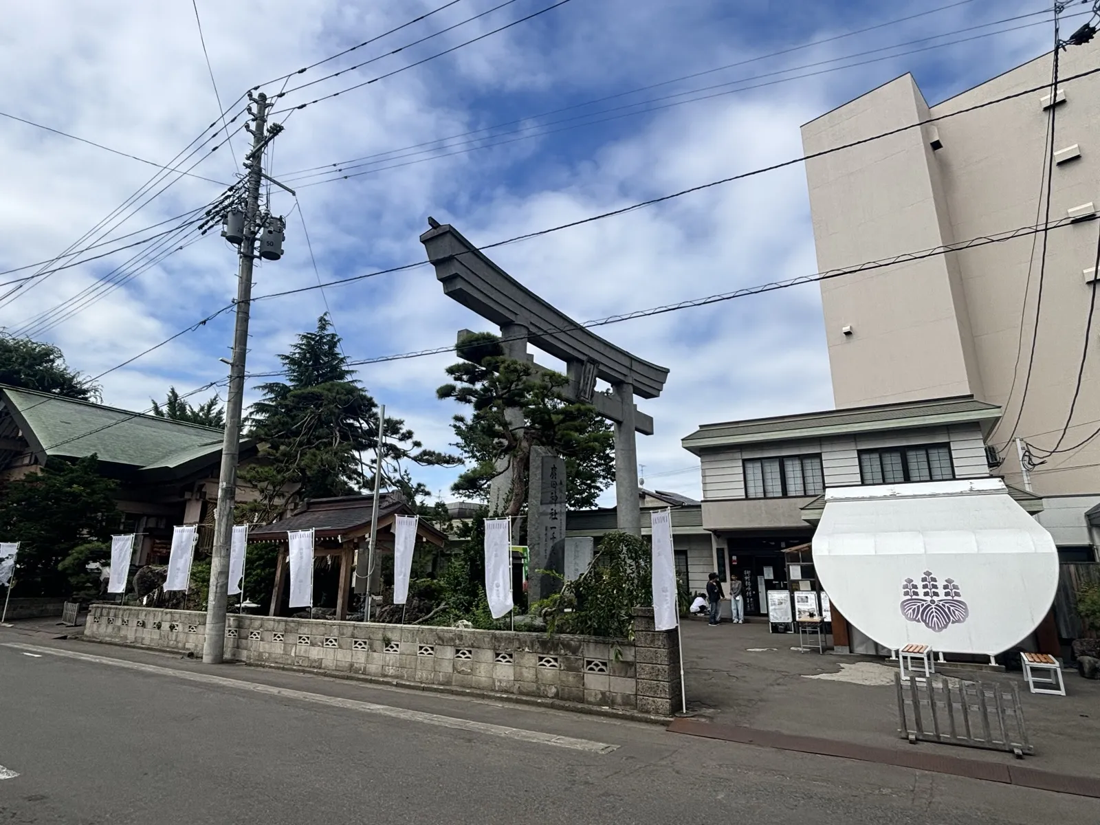 廣田神社の社頭、石鳥居と白い幟が並ぶ入口