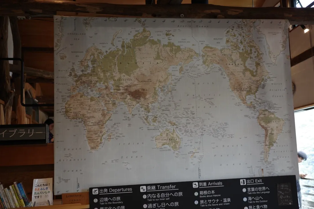 NARAYA CAFEのライブラリー。世界地図と箱根の本が並ぶ棚
