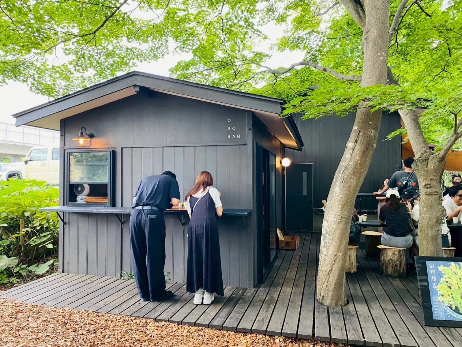 軽井沢コモングラウンズにあるOSOBARの外観と屋外テラス席
