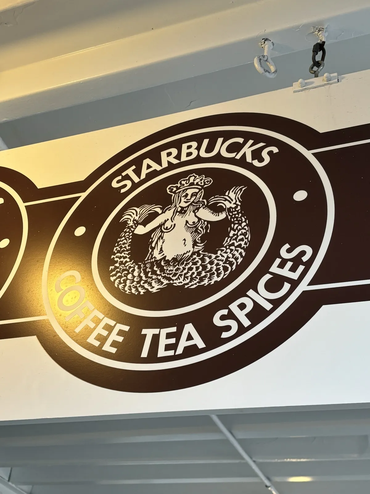 スターバックス1号店の店内に掲げられた創業時の茶色のセイレーン(人魚)ロゴ