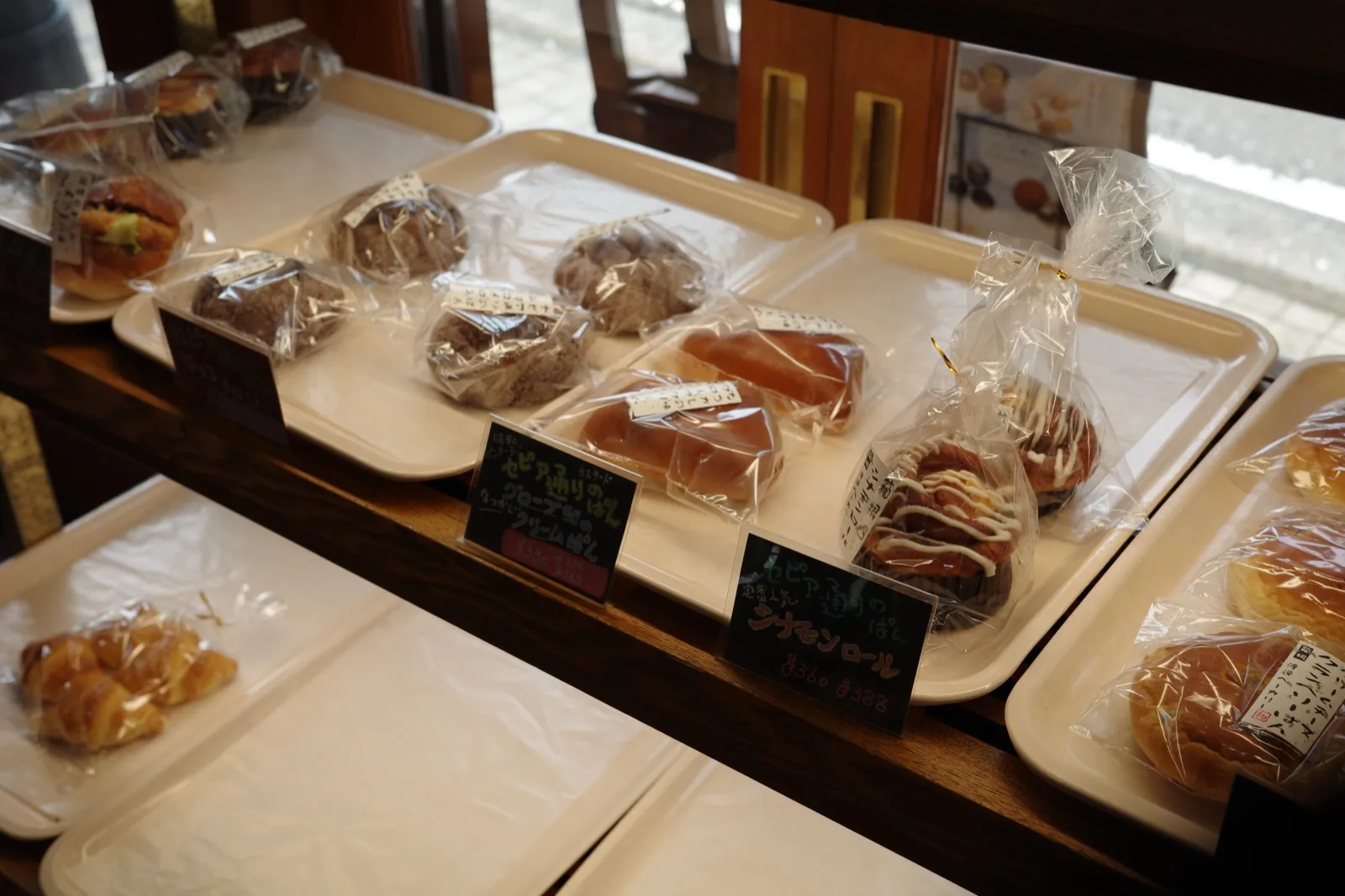 渡邊ベーカリー店内のパン陳列棚、セピア通りのパンなどが並ぶ様子