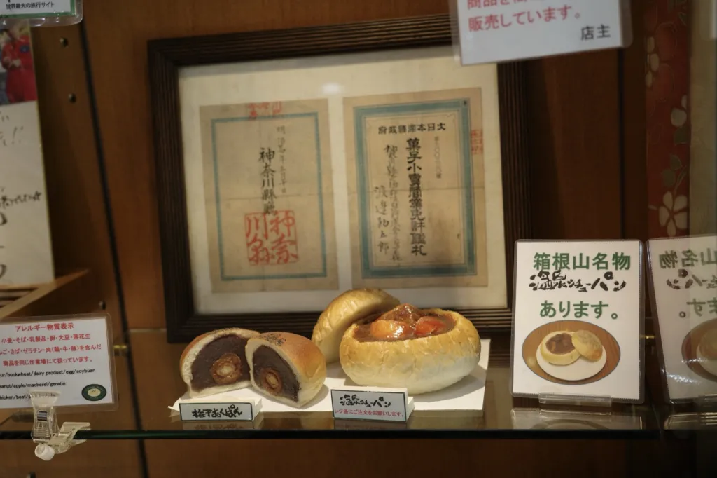 渡邊ベーカリーのショーケース、梅干あんぱんの断面と明治二十四年の菓子小売営業免許鑑札
