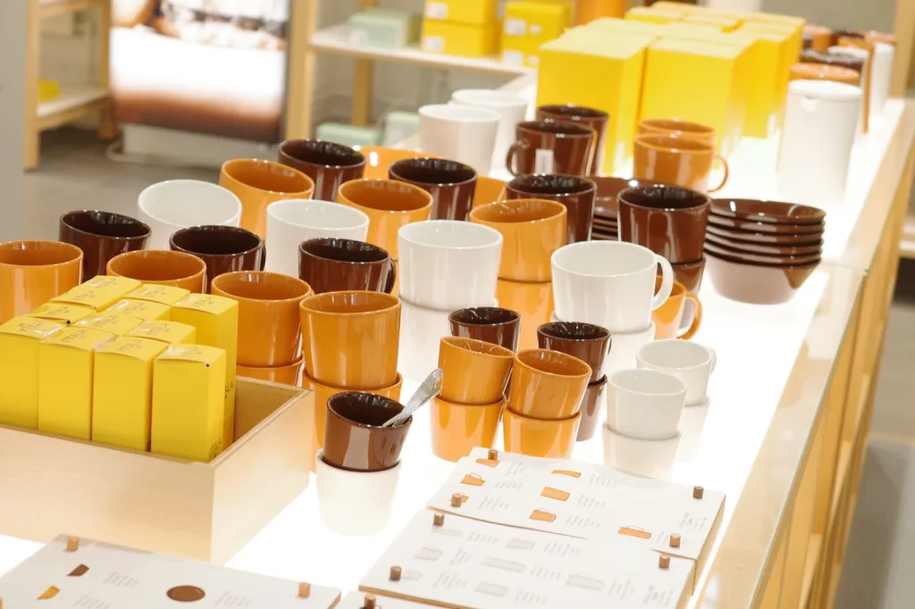 茶色やオレンジ、白の Teema のマグやボウル