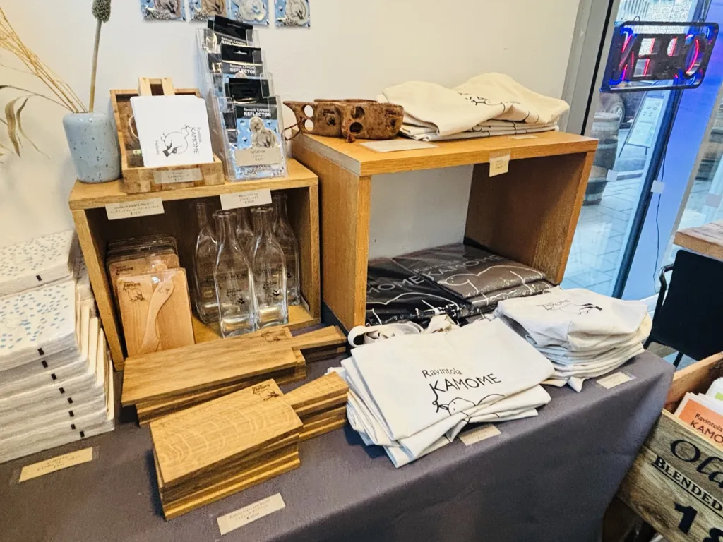 Ravintola KAMOME のロゴ入りトートバッグやエプロンが並ぶ物販棚