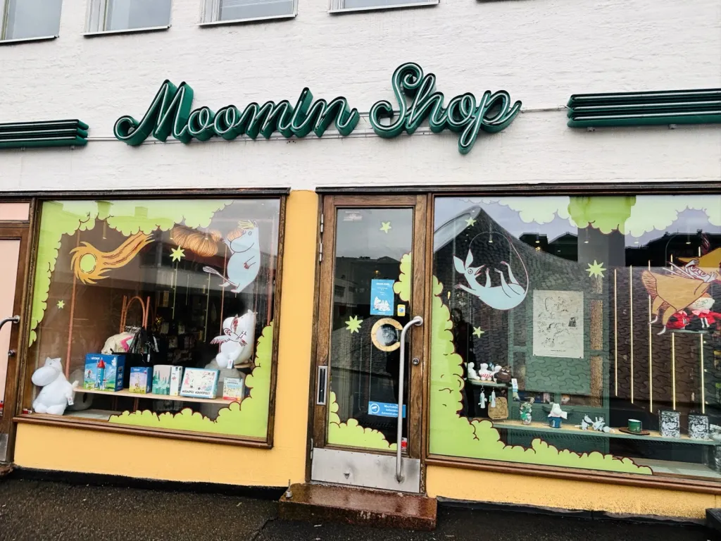 Moomin Shop の看板がかかった店の外観とショーウィンドウ