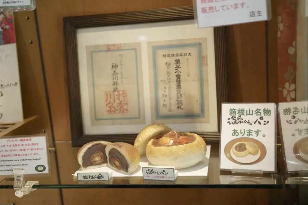 渡邊ベーカリーのショーケース、梅干あんぱんの断面と明治二十四年の菓子小売営業免許鑑札